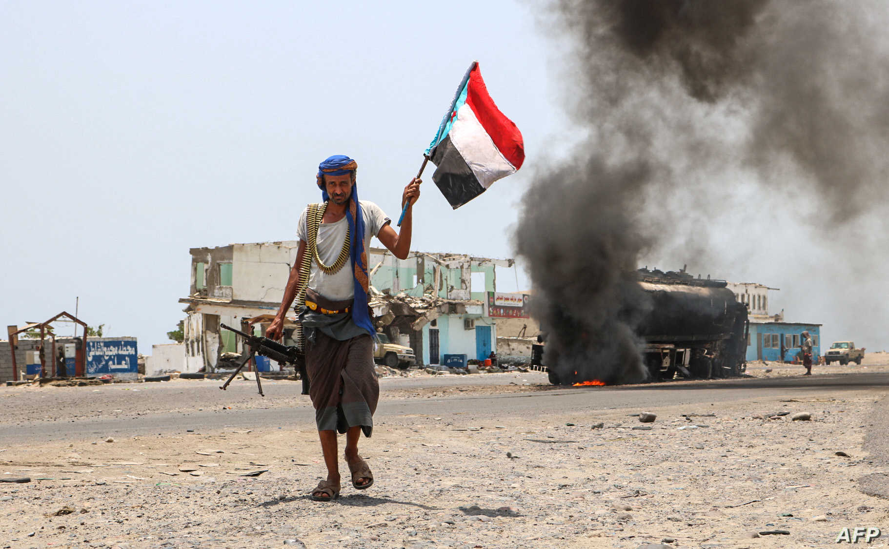 (FILES) In this file photo taken on August 30, 2019 A fighter of the UAE-trained Security Belt Force, dominated by members of the Southern Transitional Council (STC) which seeks independence for south Yemen, walks with a separatist flag past an oil tanker set ablaze during clashes between the separatists and the Saudi-backed government forces at the Fayush-Alam crossroads on the eastern entrance Aden from the Abyan province in southern Yemen. - The Saudi-led coalition backing the Yemeni government against Huthi rebels in Yemen's conflict announced on March 29 a halt to military operations during the Islamic fasting month of Ramadan from Wednesday morning. (Photo by Nabil HASAN / AFP)